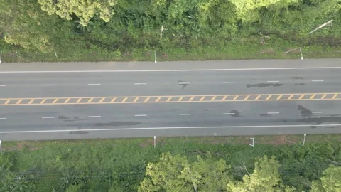 A video from a drone slowly flying from a long straight road with cars moving Stock Footage 259644183
