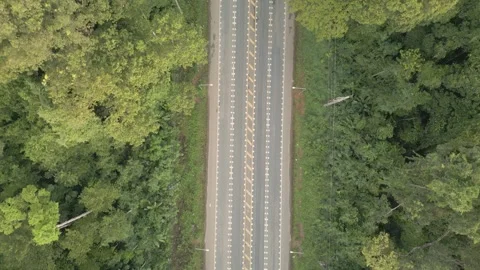 A video from a drone slowly flying from a long straight road with cars moving Stock Footage 259644846