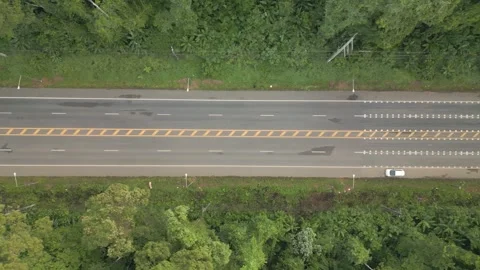 A video from a drone slowly flying from a long straight road with cars moving Stock Footage 259644933
