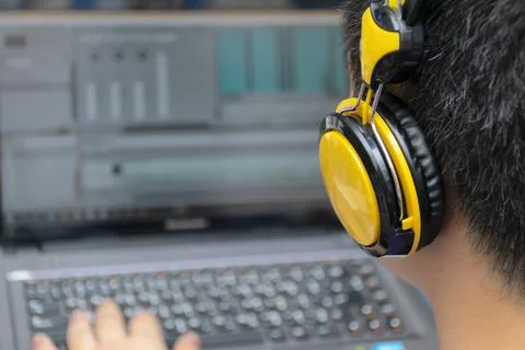 Video editing,Back view of young man using computer software and wearing head Fotos de archivo