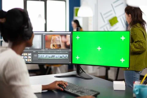 Video editor developing new project film montage looking at green screen Foto stock