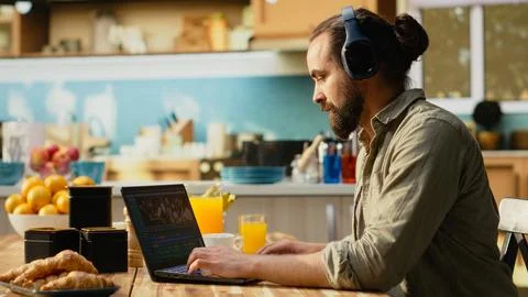 Video editor, editing with headset, video content indoors, using a laptop Stock Photos