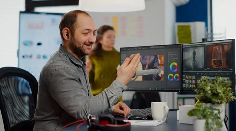 Video editor talking on videocall holding smartphone Stock Photos