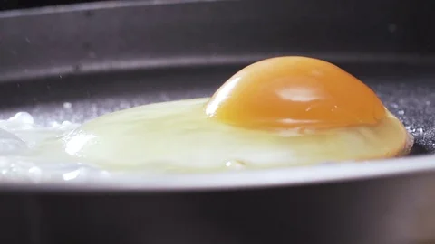 Video of egg being dropped on hot pan Stock Footage 72415297
