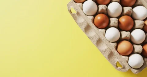 Video of eggs in packaging box on a yellow surface Stock Footage 339412534