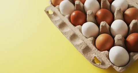 Video of eggs in packaging box on a yellow surface Stock Footage 341735771