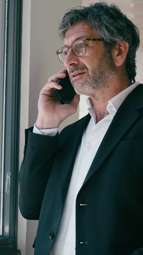 Video of elegant businessman talking with smartphone standing at the office. Stock Footage 340829366