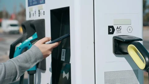 Video of elegant man paying with mobile phone for charging electro car at t.. Stock Footage 243176776