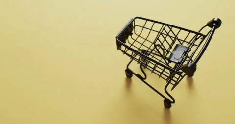 Video of empty shopping trolley with copy space on yellow background Stockbeeldmateriaal 331246361