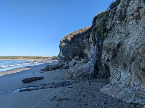 Video of a expansive view of a rugged sandy beach and steep cliffs Stock Photos