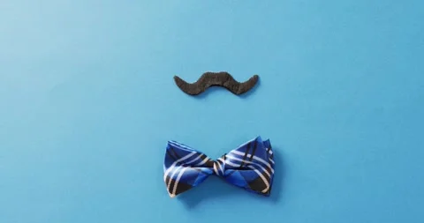 Video of false moustache with blue checked bow tie on blue background with copy 스톡 동영상 331307080