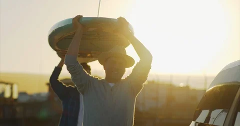Video of father and son loading paddleboards on car. Stock-Footage 88377722