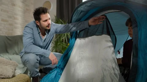 Video of father and son preparing tent at home. Video stock 154637817