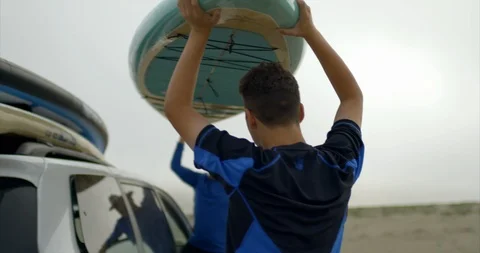 Video of father and son unloading paddleboards at beach. 스톡 동영상 88377828