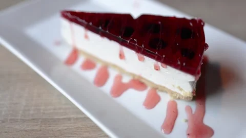 The video features a decadent cheesecake adorned with a glossy red jelly Video stock 265744835
