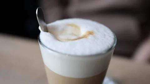 The video features a latte coffee cup with a frothy layer on top Видео 266894061