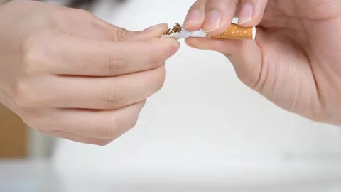 Video featuring a cigarette being cut or discarded, symbolizing quitting smoking Stock Footage 322024060