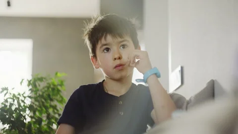 A video featuring a young boy in various settings, including sitting on a couch Stock Footage 275252600