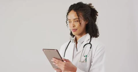 Video of female doctor with stethoscope using tablet on white background Stock Footage 336783501