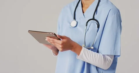 Video of female doctor using tablet on blue background Stock Footage 337025013