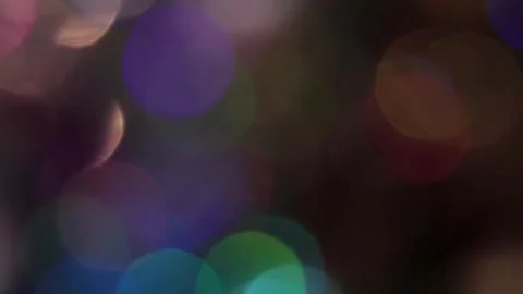 Video of a flash of colored bokeh light moving slowly in the dark Vidéo 317459099