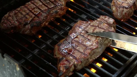 Video of flipping over steaks on the grill in real slow motion Stock Footage 78635528