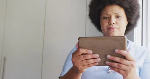 Video of focusedplus size african american female doctor using tablet Stock Footage 336714366