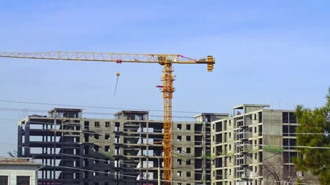 Video footage from a construction site where a yellow tower crane is being .. Stock Footage 340609397