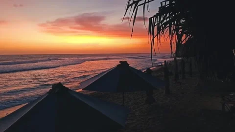 Video footage of a red sunset on the beach with beautiful umbrellas Stock Footage 327523196