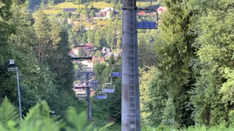 Video of a funicular ascending a mountain through lush green trees in summer Stock Footage 318953256