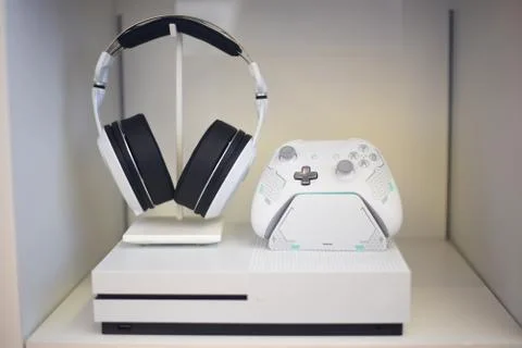 Video game console, controller, and headset on display Stock Photos
