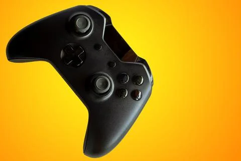 Video game controller and game controller. Orange background. Selective focus Stock Photos