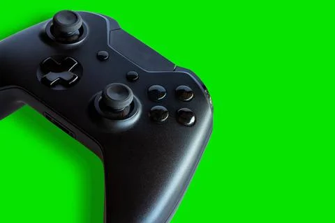 Video game controller and game controller. Green background. Selective focus. Stock Photos
