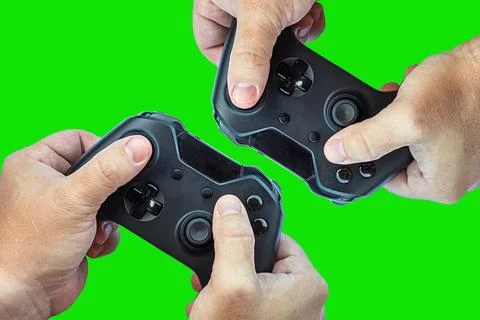 Video game controller and game controller. Green background. Selective focus. Stock Photos