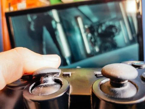 Video game controller closeup from console against monitor screen. Stock Photos