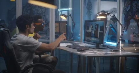 Video game developers discussing computer graphics Stock Photos