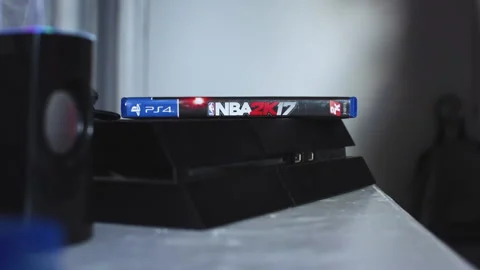 A video game getting ejected out of the Playstation 4 to insert two Stock Footage 138786427