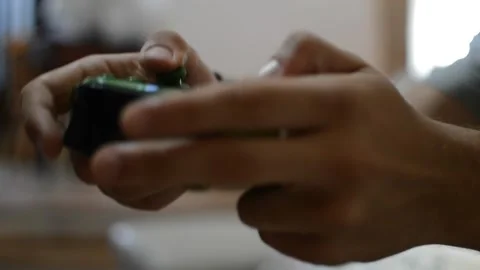Video game player using a green controller in a blur home background 動画素材 201080974