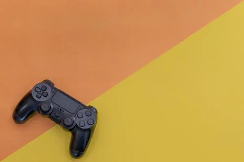 Video games black gaming controller isolated on yellow blue color background Stock Photos