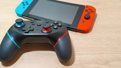 Video gaming technology handheld red and blue vibrant console and pro controller Stockbeeldmateriaal 318310914