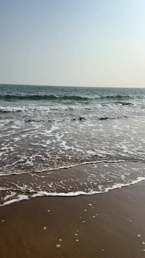 Video of gentle ocean waves lapping on sandy shore at sunrise Vídeos de archivo 333605262