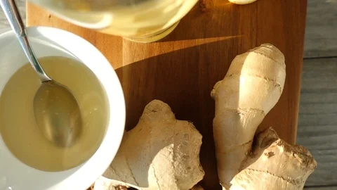 VIDEO, ginger root, honey and a cup of hot tea rotating in slow motion Stock Footage 100809382