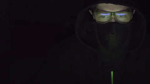 Video of a hacker with covered face while working on the computer. Stock Footage 105489594