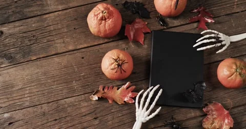 Video of halloween skeleton hands, notebook and decorations with copy space on Stock Footage 331208868