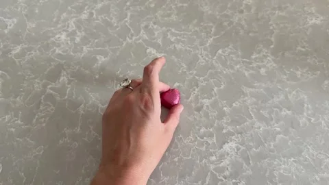 Video of hand with oval cut diamond ring and pink hearts for Valentine's Day. 스톡 동영상 314744970