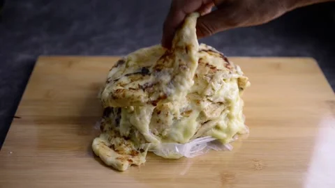 Video of Hand picking a pupusa from a stack of pupusas on a wooden board and  스톡 동영상 221275330