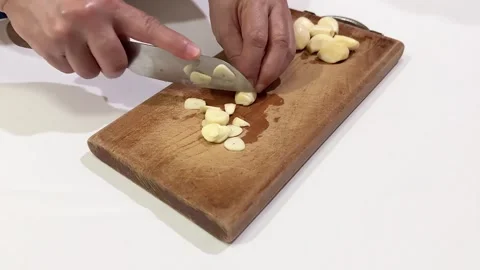 Video of hands cutting garlic on a chopping board. Isolated on white background Vídeos de archivo 287583500