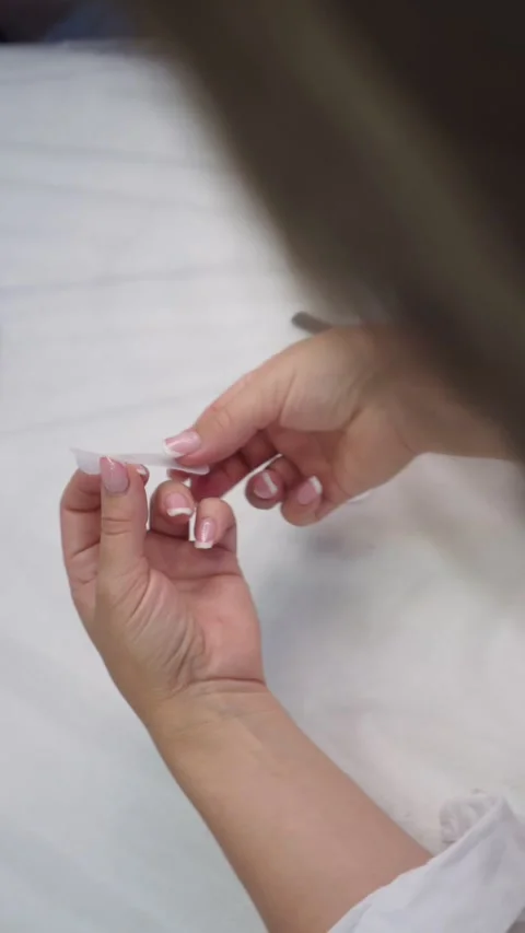Video of hands of master working indoors, removing sticker for patch with Vídeos de archivo 251638343