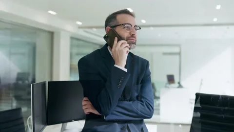 Video of handsome executive in suit talking with smartphone in the modern o.. Stock Footage 237692574