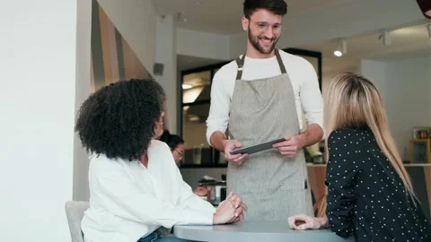 Video of handsome smiling waitress using application on digital tablet comput Stock Footage 193410770